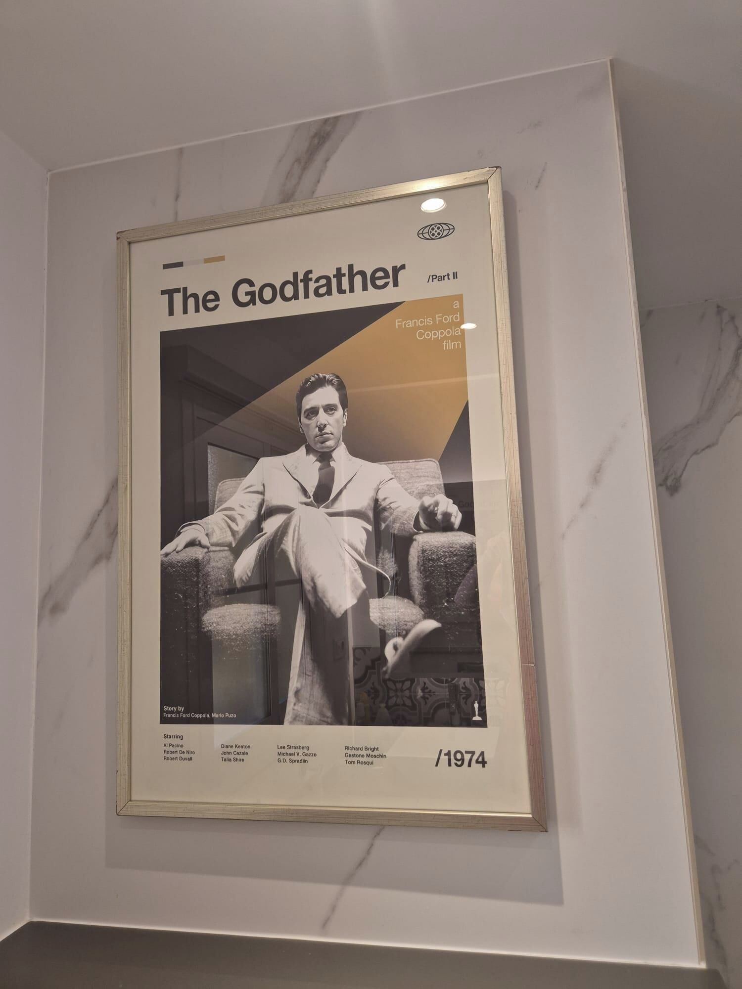 A framed movie poster of 'The Godfather Part II' from 1974, featuring a seated man in a suit.