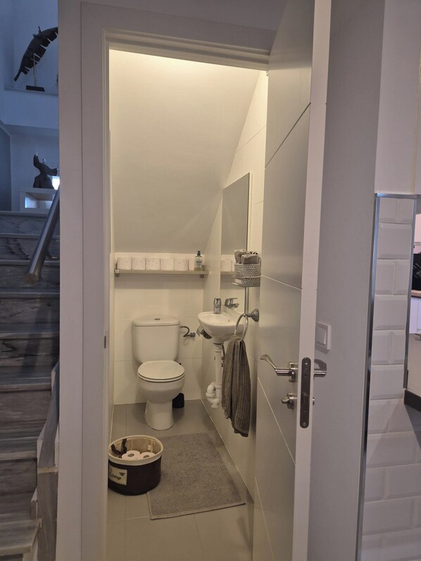 A compact bathroom with a toilet, sink, and towel rack. - Newly Refurbished Luxury 3 Bed Duplex Apartment (Fuengirola)
