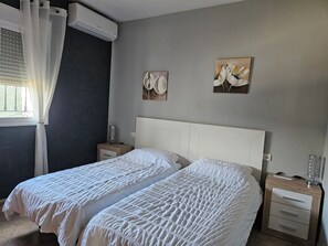 A bedroom with two beds, a nightstand with a lamp, and artwork on the wall. - Villa - Sleeps 4 - Pool - Patio - Parking (Arboleas)
