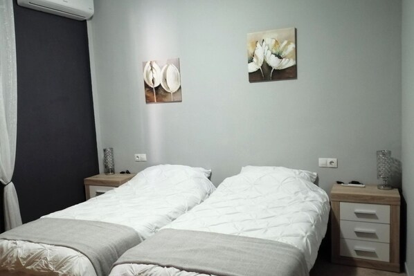 A hotel room with two beds, a bedside table with a lamp, and two wall-mounted paintings. - Villa - Sleeps 4 - Pool - Patio - Parking (Arboleas)