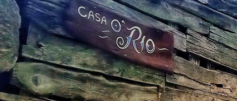 A rustic wooden wall with the text "CASA O'RIO" painted on it.