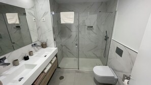 A modern bathroom with a glass-enclosed shower, a white sink with a mirror, and a toilet. - Modern Luxurious 3-bed Apartment in La Quinta Golf (Benahavis)