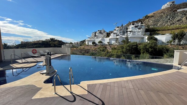 A rooftop pool with a clear view of a hillside with white buildings. - Modern Luxurious 3-bed Apartment in La Quinta Golf (Benahavis)