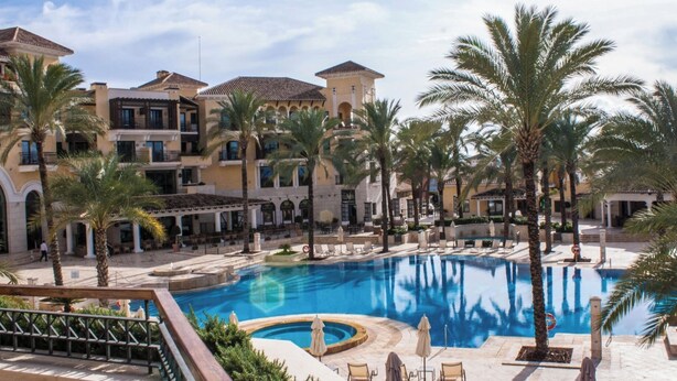 A resort with a central swimming pool surrounded by palm trees and a multi-story building with balconies. - Apt Sleeps 4 With Pool Access (Torre-Pacheco)