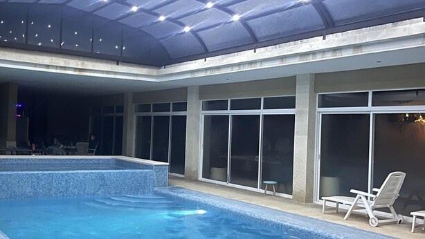 An indoor swimming pool with clear water, a ceiling with lights, and a few lounge chairs. - Stunning 3 Bedroom Rural Apartment Near Pinoso (Pinoso)