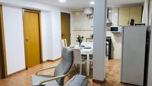A compact living space with a dining area, kitchenette, and a sofa. - Impeccable 3-bed Apartment in Puerto de Sagunto (Sagunto)