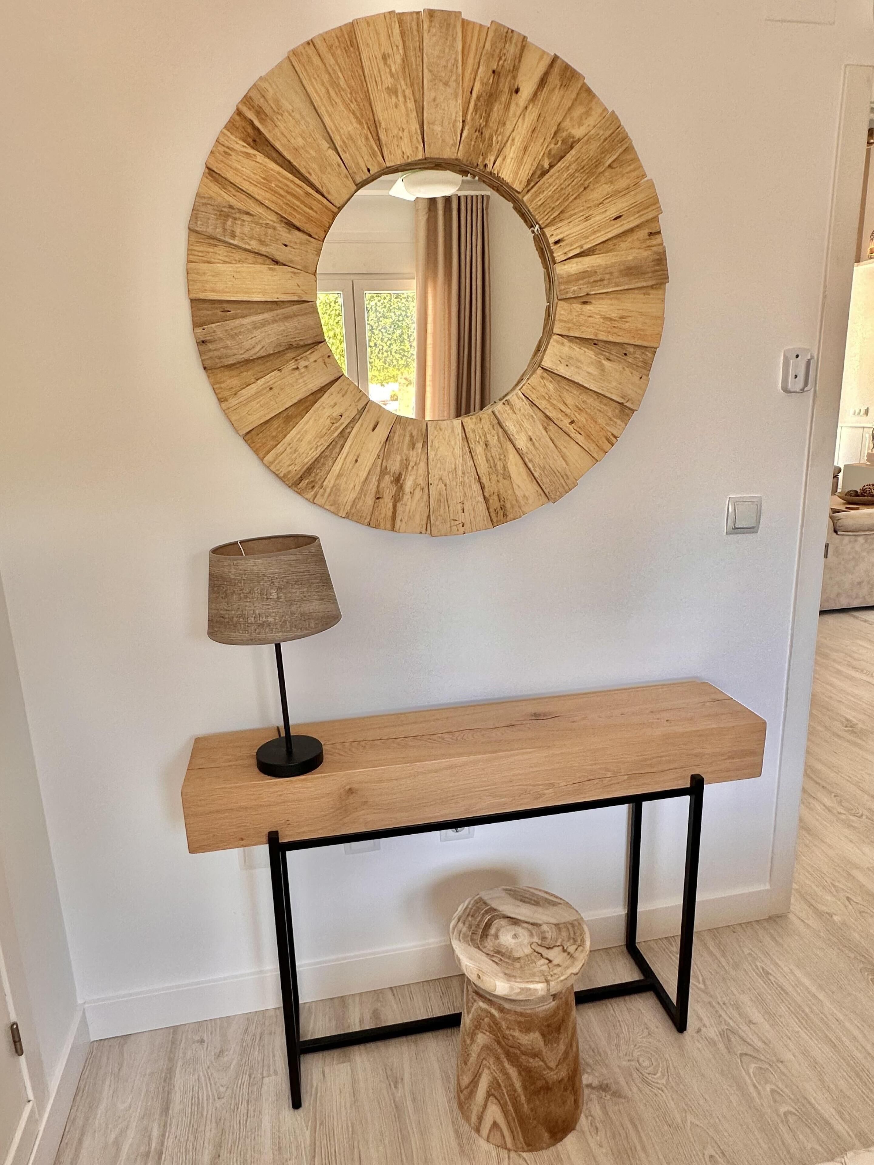Een houten console tafel met een spiegel erboven.