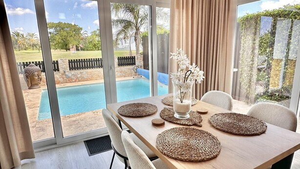 A dining area with a wooden table, woven placemats, and a Buddha statue. - Casa Bonita Sleeps 4 With Private Pool (Torre-Pacheco)