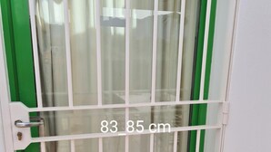 A door with a metal security gate, measuring 83-85 cm, and a green frame. - Sunset Villa not for Rent (Pulpi)