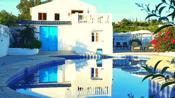 Une piscine avec un bâtiment blanc en arrière-plan.