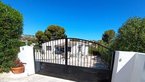 A gated entrance with a white wall and a black gate. - Moraira Escape With Private Pool, 1 Bed, Sleeps 2 (Teulada)