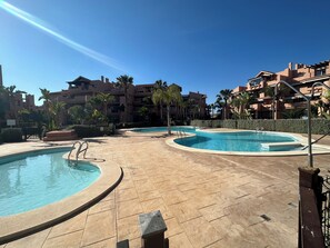 A resort with multiple swimming pools, palm trees, and a clear blue sky. - Mar Menor Golf Resort - 2 Bedroom Apartment (Torre-Pacheco)