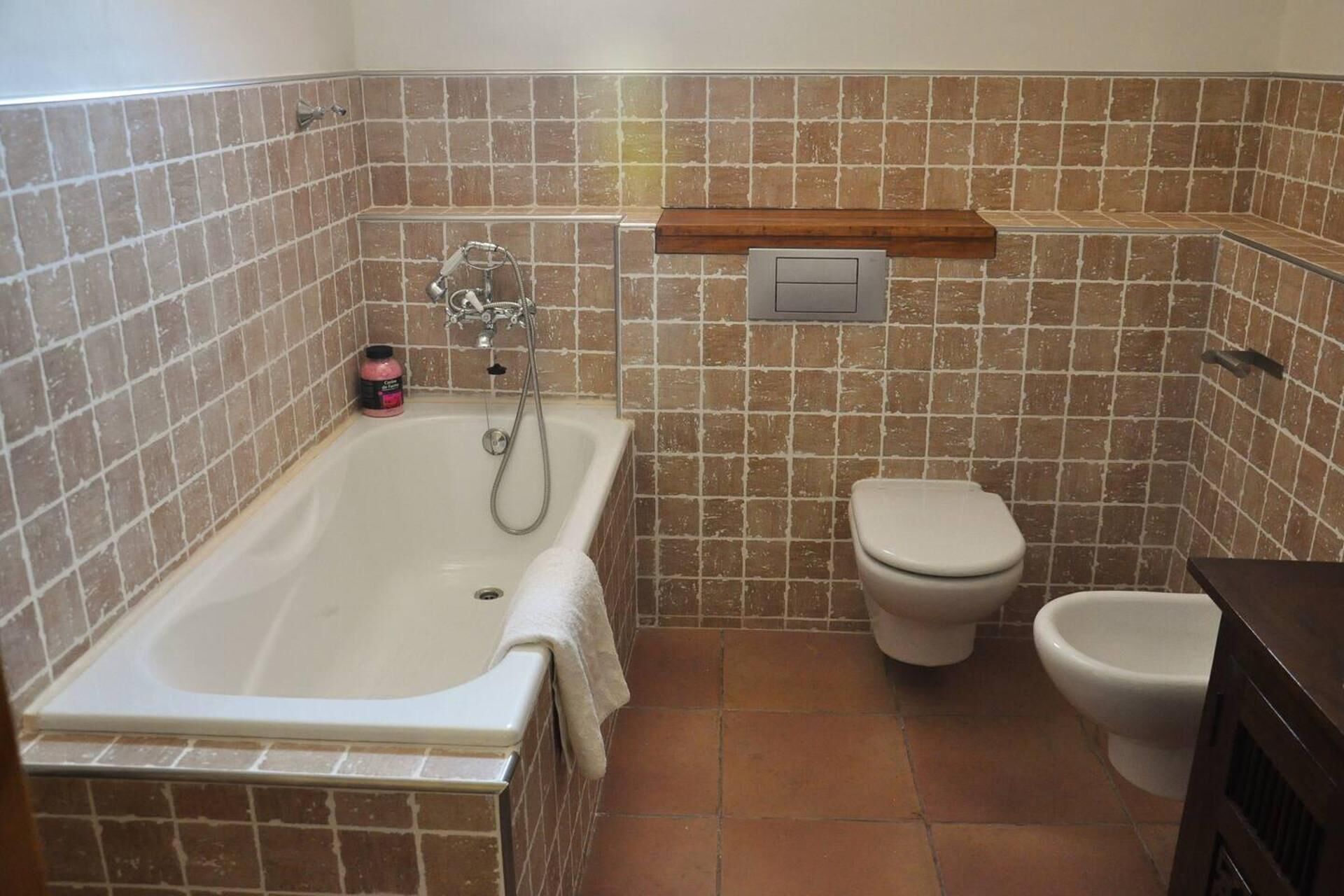 Een badkamer met een bad, toilet en bidet.