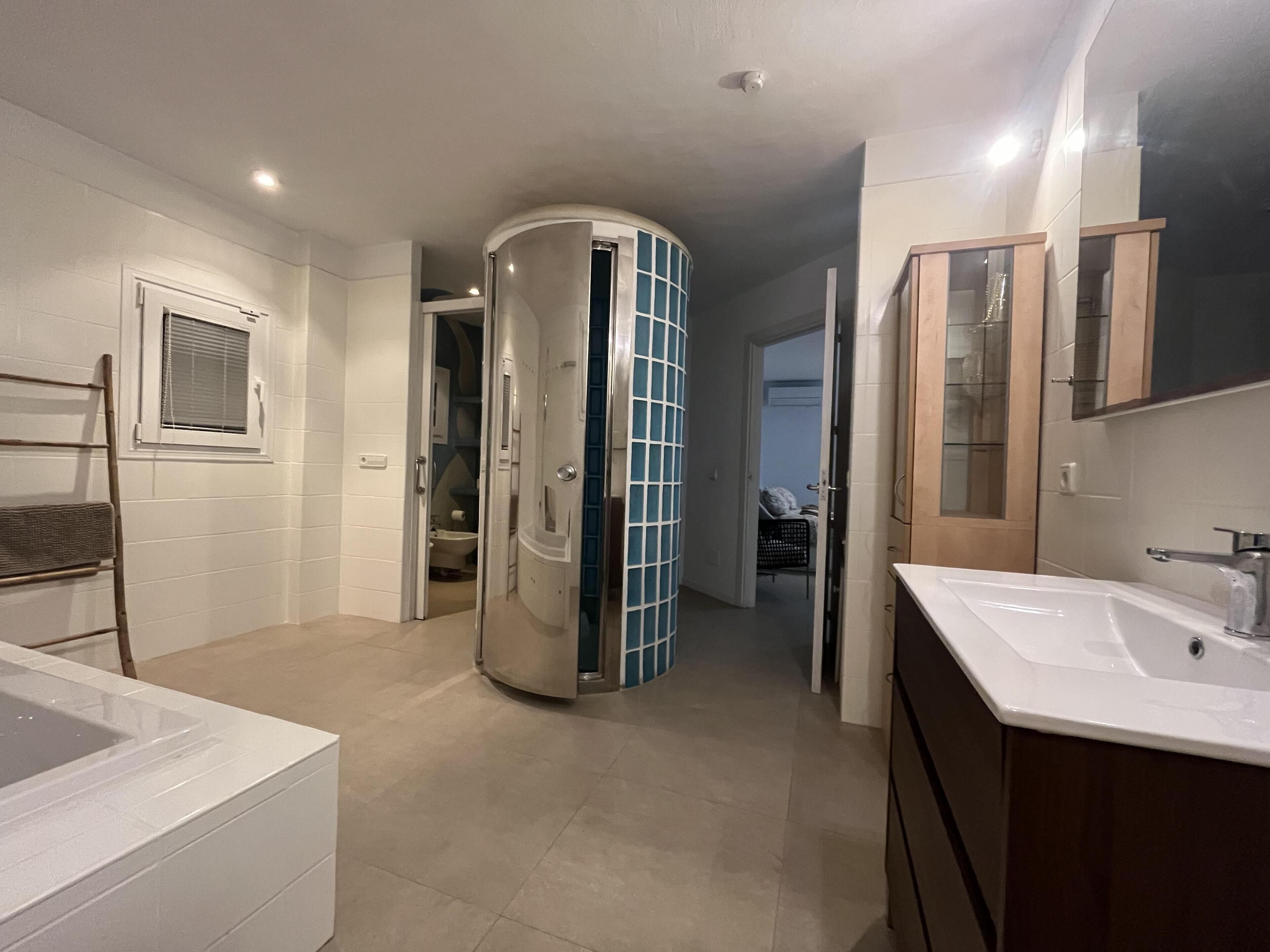 Huis | Badkamer | Een bad/douchecombinatie, een diep bad, een haardroger, handdoeken