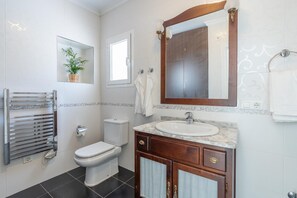 Un bagno moderno con il water, un lavandino e un porta asciugamani.