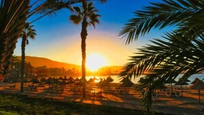 A beach scene with palm trees and a sunset. - Beautiful Villa - Near Los Cristianos (Arona)