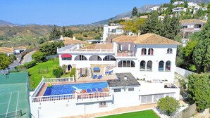 A large white villa with a swimming pool, multiple balconies, and a tennis court. - Most Luxurious Villa on the Costa del Sol (Mijas)
