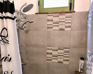 A shower area with a rain showerhead, a towel rack, and a bottle of shower gel on the wall. - Aurora 2-bed Cottage - Sleeps 4 - Montseny Park (Arbucies)
