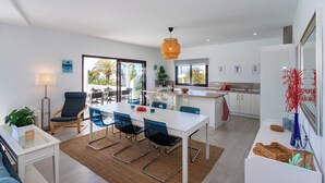 Un ambiente moderno con zona pranzo, cucina e ampie finestre.