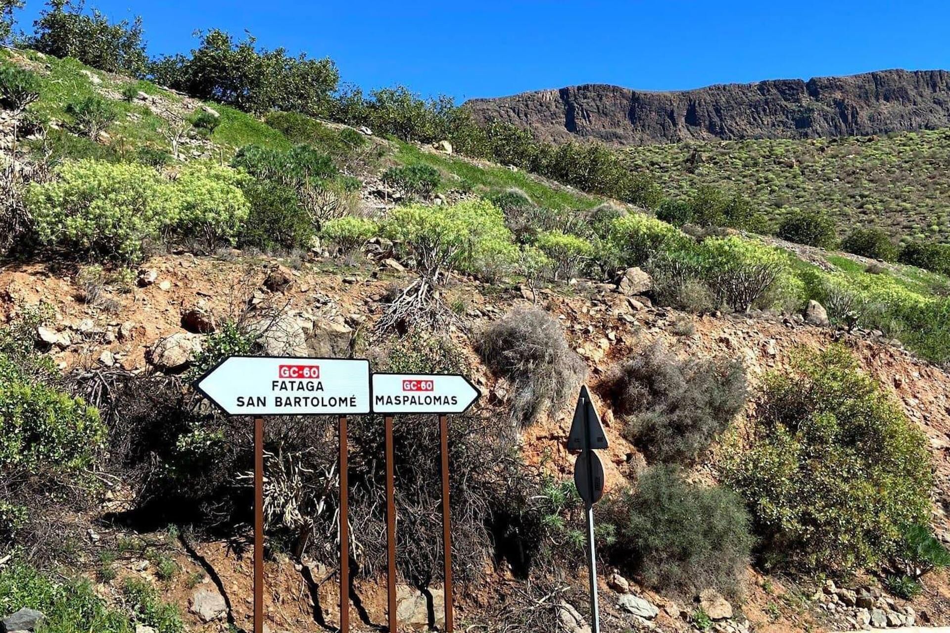 A directional signpost with destinations Fataga, San Bartolomé, and Maspalomas.