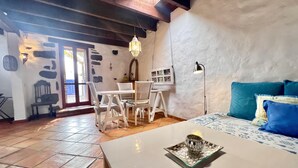 Une pièce chaleureuse avec une table à manger, des chaises, un canapé et une lampe.