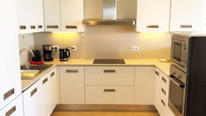 A compact kitchen with white cabinets, a stainless steel sink, a coffee maker, a microwave, and a stove. - Amazing Sunset Golf-course Villa for up to 7 (San Bartolomé de Tirajana)