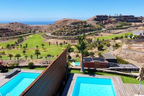 Et resort med flere swimmingpools, en golfbane og udsigt til havet.