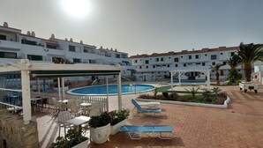 A pool area with lounge chairs and a covered seating area. - 1 Bed Apartment - Sleeps 2 - Pool - Parking (Arona)