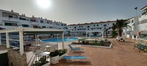 A pool area with lounge chairs and a covered seating area. - 1 Bed Apartment - Sleeps 2 - Pool - Parking (Arona)