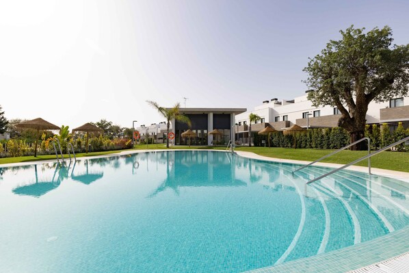 Relax by the pool surrounded by lush greenery and tropical plants.