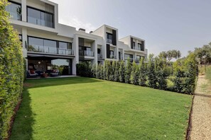 Stylish residential building with large windows and lush green surroundings.