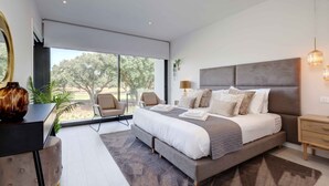 Un dormitorio moderno con una cama grande, un escritorio y vistas al exterior.