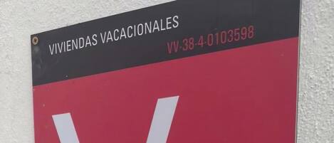 A sign with the text "VIVIENDA VACACIONALES" and a large white letter "V" on a red background.