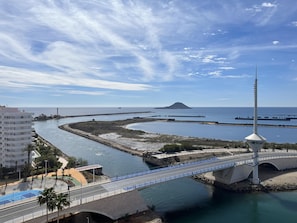 A coastal area with a bridge, a lighthouse, and a water body. - Vista Marina Apartment - La Manga del Mar Menor (San Javier)
