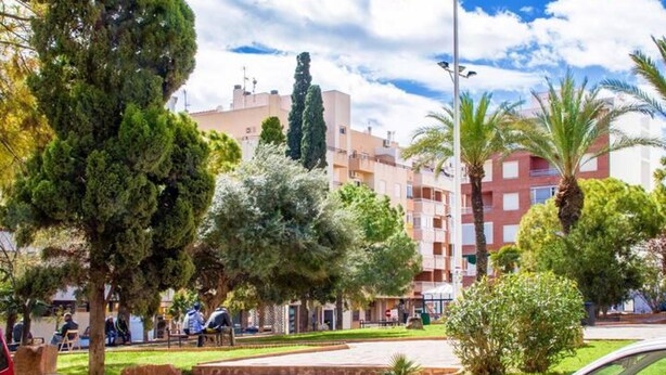 A courtyard with steps leading to a building, surrounded by trees and a parked car. - Amplio Apartamento Turistico en Torrevieja (Torrevieja)