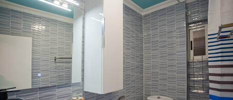 A bathroom with a modern design, featuring a sink, toilet, and shower area.