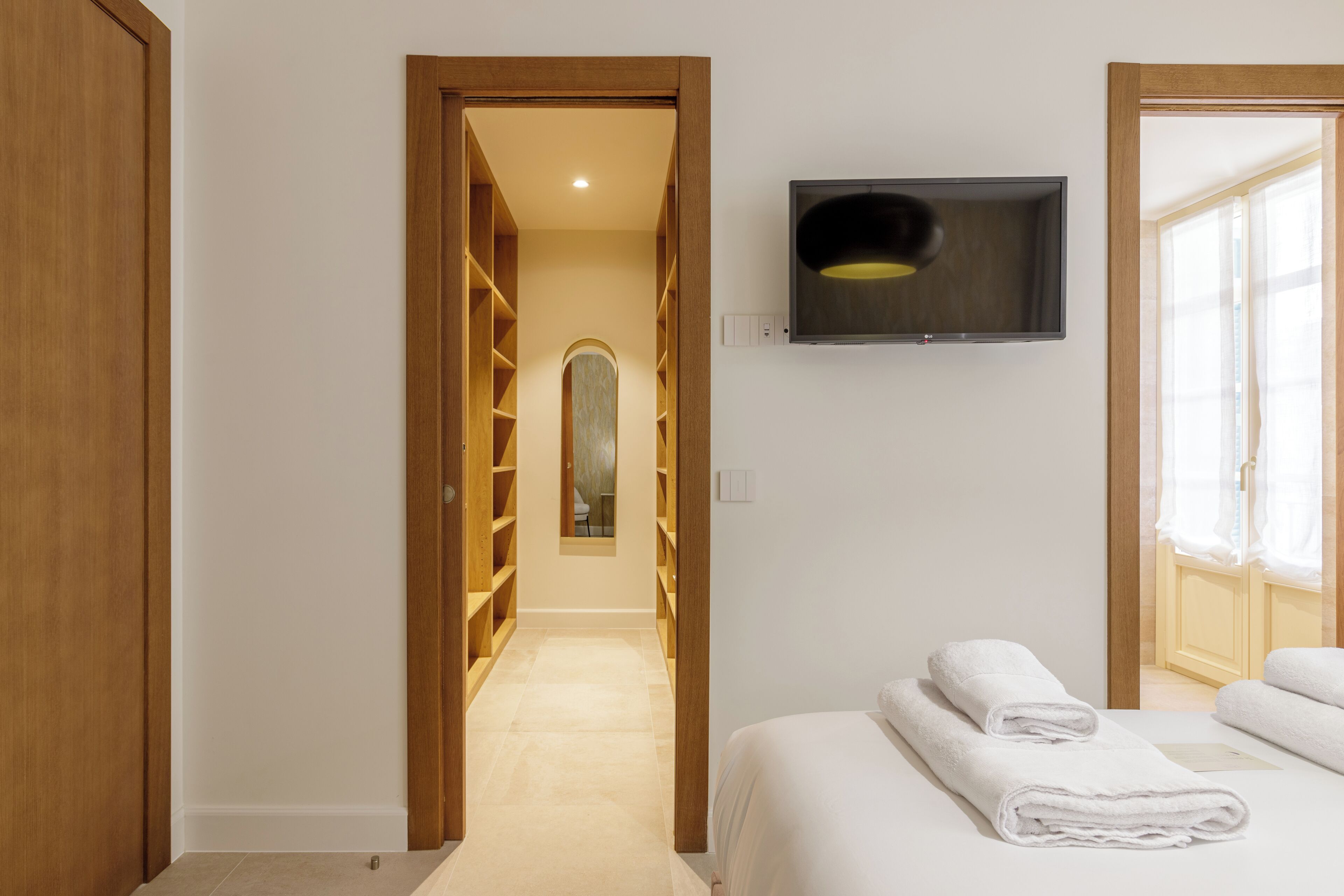 Ein Hotelzimmer mit einem Bett, einem an der Wand befestigten Fernseher und einem Holzschrank.