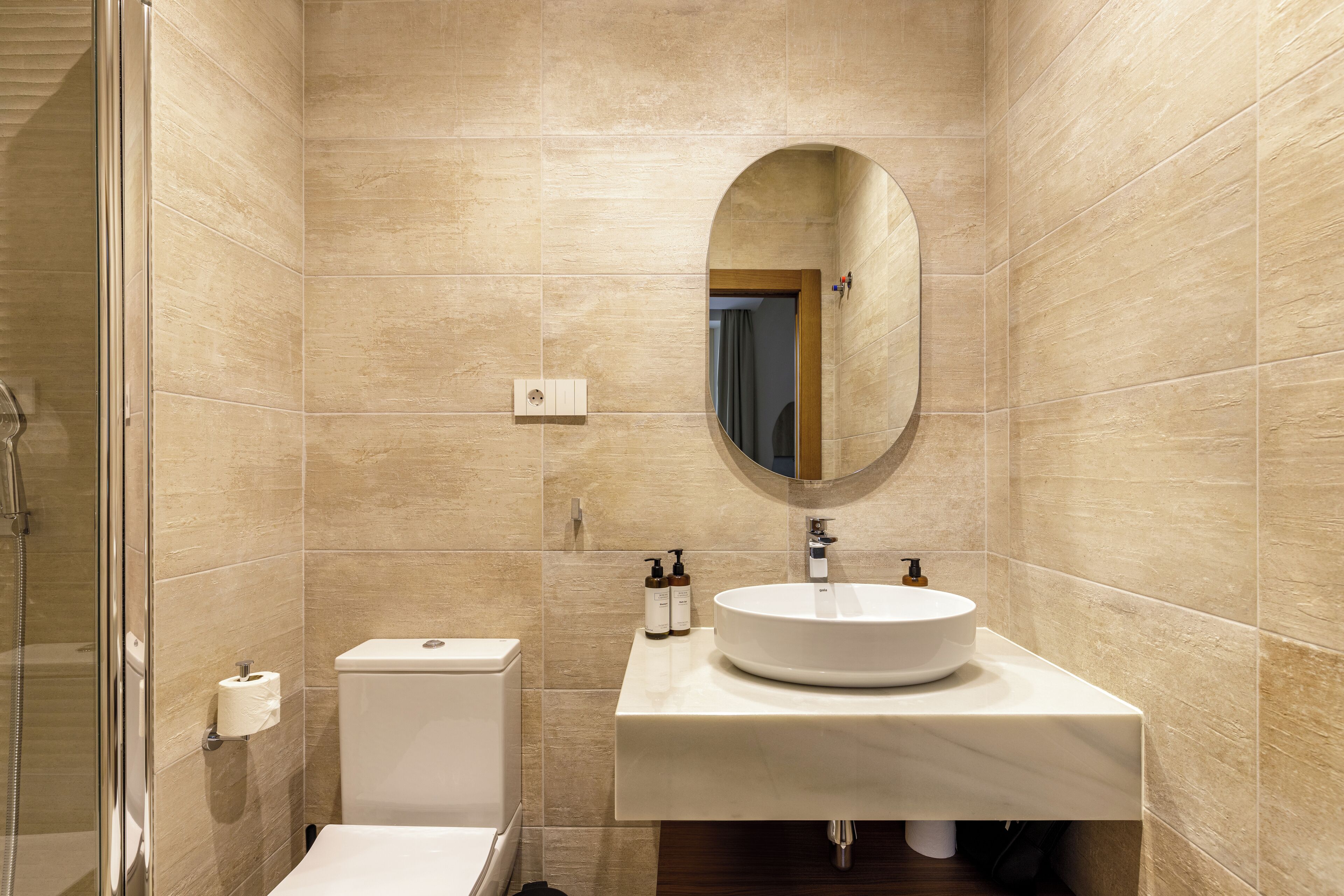 A modern bathroom with a toilet, sink, and shower.