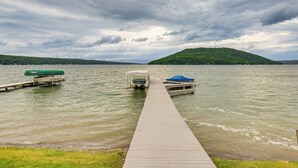 A wooden pier extending into a lake with boats docked at the end.
