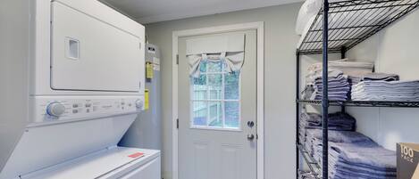 Une buanderie avec des piles de serviettes, un sèche-linge et un lave-linge.