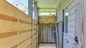 A narrow wooden hallway with a door leading to a room.