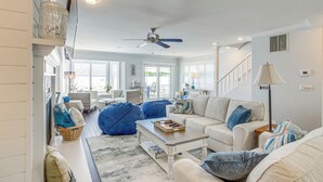 Ein geräumiges Wohnzimmer mit Deckenventilator, Couchtisch und Sofa.
