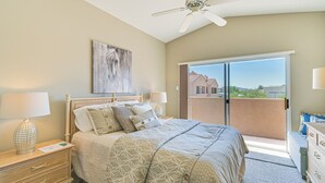 A bedroom with a bed, bedside lamps, a ceiling fan, a painting, and a view through a sliding door to the outside. - Patio & Pool Access: Lake Havasu City Gem (Lake Havasu City)