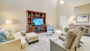 A spacious living room with a large flat-screen TV, comfortable seating, and a decorative cabinet. - Patio & Pool Access: Lake Havasu City Gem (Lake Havasu City)