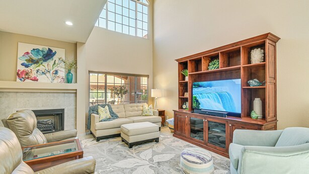 A spacious living room with a fireplace, a large flat-screen TV, and a high ceiling with skylights. - Patio & Pool Access: Lake Havasu City Gem (Lake Havasu City)