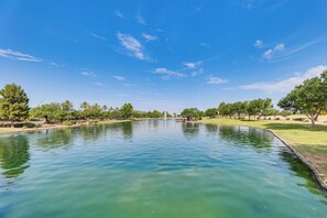 A calm lake with a fountain in the center, surrounded by trees and a clear sky. - Quiet Casa Grande House Next to Villago Park! (Casa Grande)