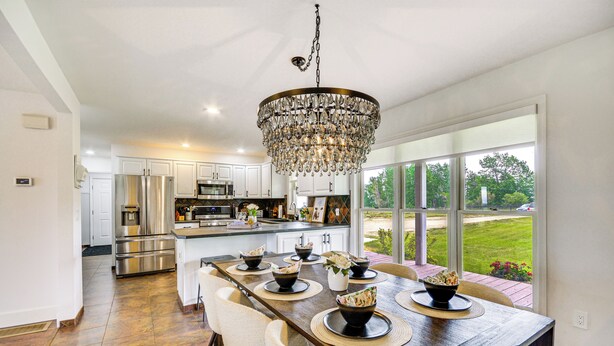 A spacious kitchen with a large island, stainless steel appliances, and a chandelier. - Lovely Roberts Home w/ Patio & Mountain Views! (Roberts)