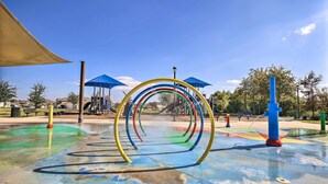 A playground with colorful play structures and a blue water feature. - Lovely San Antonio Vacation Rental w/ Private Yard (San Antonio)