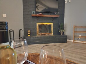 Un salon moderne avec une cheminée, des étagères en bois et une plante en pot.