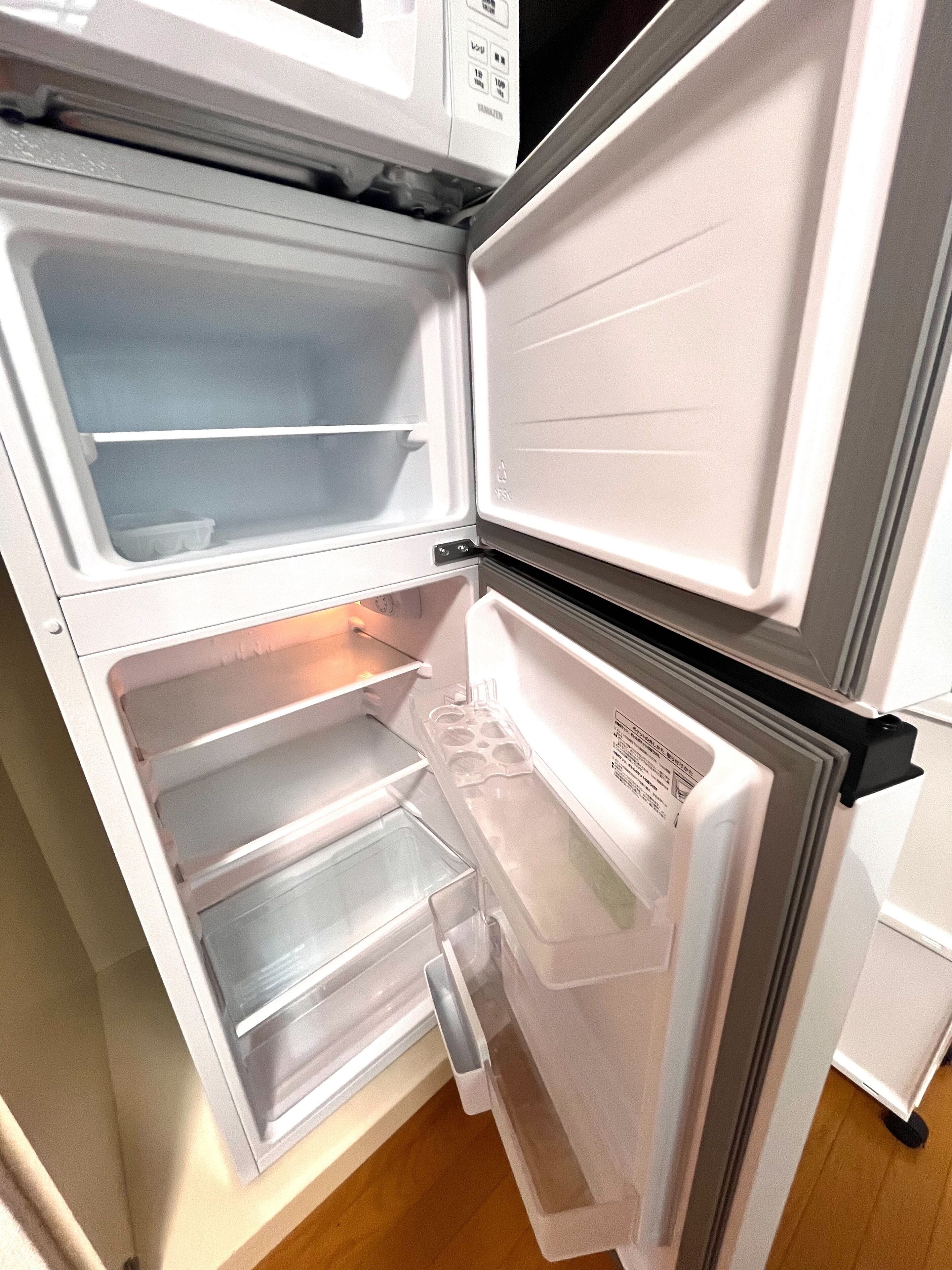 An open refrigerator with two shelves and a freezer compartment.